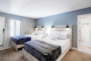 A bedroom with two beds, a window with curtains, a door, and a white wall. - Modern Waterfront Condo w/ Mountain View, W/D, & High Speed WiFi - Near Skiing (Frisco)