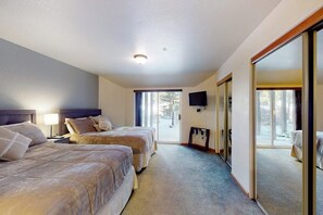 A hotel room with two beds, a television, and a sliding glass door leading to a balcony. - Peak-view townhome with convenient central location, decks & free EV charger (Frisco)