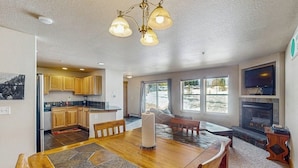 A spacious living area with a dining table, a fireplace, and a kitchen in the background. - Convenient Mountain Condo w/Free WiFi, Mtn Views, Private Washer/Dryer, & Cable (Fraser)