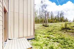 A modern building with a wooden deck and a view of a grassy area with trees. - Convenient Mountain Condo w/Free WiFi, Mtn Views, Private Washer/Dryer, & Cable (Fraser)