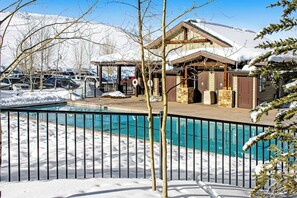 A pool area with a wooden deck, a covered seating area, and a mountain backdrop. - Ideally located mountain getaway w/ shared pool, gas grill, & scenic balcony (Granby)