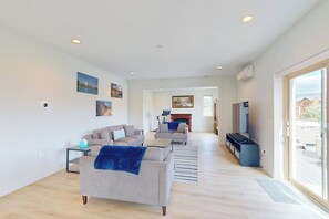 A spacious living room with a fireplace, sofas, and a television. - Gorgeous mountain home with deck, pool table, fast WiFi & fireplace - near town (Tabernash)