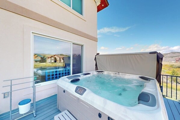 A hot tub on a balcony with a view of houses and a clear sky. - Gorgeous mountain home with deck, pool table, fast WiFi & fireplace - near town (Tabernash)