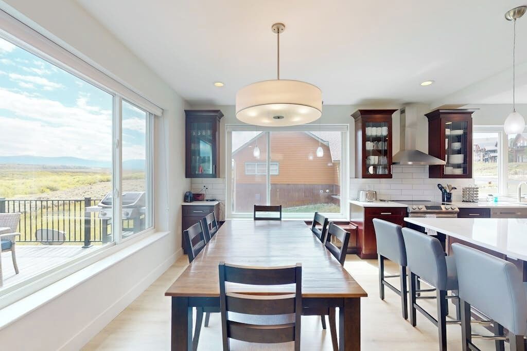 Una cocina moderna con comedor, ventanas amplias y vistas al exterior.