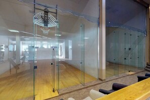 Ein modernes Interieur mit Glaswänden, einem Basketballkorb und Holzboden.