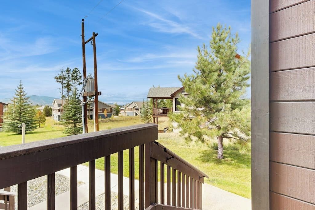 A residential area with houses, a wooden deck, and a clear sky.