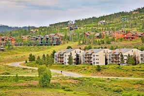Ein Wohngebiet mit mehrstöckigen Gebäuden, einer kurvenreichen Straße und hügeliger Landschaft.