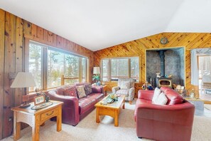 Ein gemütliches Blockhaus-Interieur mit Holzausstattung, Kamin, Sofa und Couchtisch.