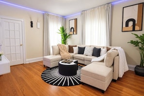 A modern living room with a sectional sofa, a coffee table, and a potted plant.