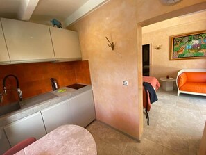 A compact living space with a kitchenette, a dining area, and a sofa. - Air-conditioned studio - Terrace and Spa (Aix-en-Provence)