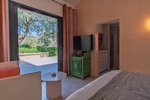 A room with a bed, a small table, a TV, and a green cabinet. - Air-conditioned studio - Terrace and Spa (Aix-en-Provence)
