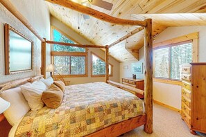 A bedroom with a wooden four-poster bed, large windows, and a wooden dresser. - Dog-friendly mountain home with fireplace, firepit & ping-pong - great for kids (Tabernash)