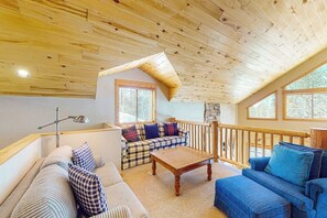 A cozy room with a wooden ceiling, a checkered sofa, a blue couch, and a wooden table. - Dog-friendly mountain home with fireplace, firepit & ping-pong - great for kids (Tabernash)