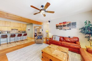 Eine moderne Küche mit Holzausstattung, einer Bar und einer roten Ledersofa, sowie einem Deckenventilator.