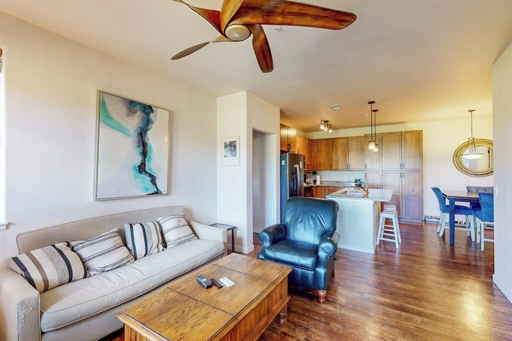 Un salon avec un canapé, une table basse et un ventilateur de plafond.