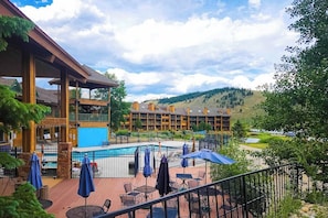 Ein Hotel mit Pool, Außenbereich und Blick auf eine Berglandschaft.