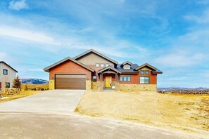 A two-story house with a garage, a front porch, and a driveway. - Dog-friendly golf course-front home with mtn & ski views, fireplace, & balconies (Granby)