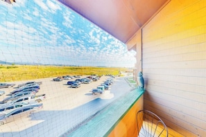 A view of a parking lot with multiple cars, a clear sky, and a building with a sloped roof. - 3rd-floor condo with balcony, indoor & outdoor pools, game room, gym, W/D (Granby)