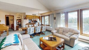 Ein Wohnzimmer mit einer Couch, einem Couchtisch und einem Essbereich mit Stühlen und einem Tisch.