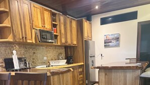 Eine Küche mit Holzausstattung, Steinfliesen und einer Bar.