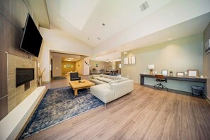 Eine moderne Hotelhalle mit Flachbildfernseher, Kamin, einer Couch, einem Couchtisch und einer Rezeption.