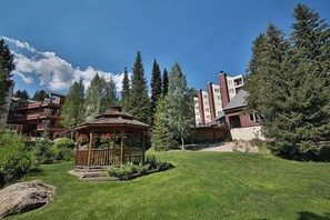 Ein Hotel mit einem Pavillon, üppigem Grün und hohen Bäumen.