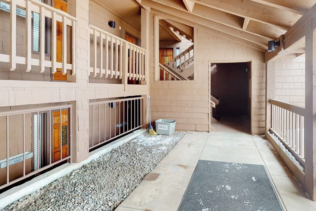 A multi-level building with a wooden interior, a gravel pathway, and a metal trash bin.