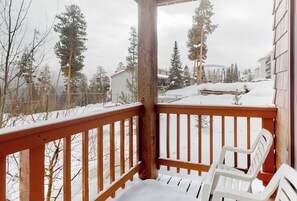 Ein h ölzerner Balkon mit schneebedecktem Boden und Blick auf schneebedeckte Häuser und Bäume.