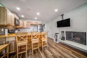 A modern kitchen with wooden cabinets, a stone backsplash, a built-in microwave, and a fireplace. - Second-floor condo with fireplace, hot tub & indoor pool - dog-friendly (Winter Park)