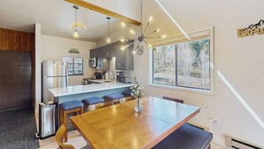 Une cuisine moderne avec un îlot central, des tabourets de bar et une table à manger.