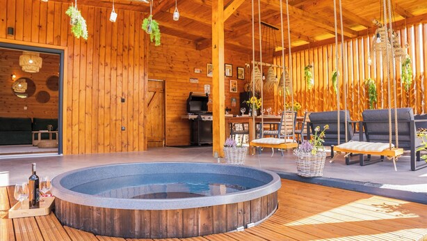 Un intérieur en bois comprenant un jacuzzi, un coin salon et une cuisine.