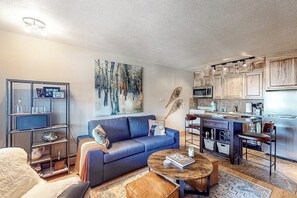 Ein Wohnzimmer mit einer Couch, einem Couchtisch und einem Bild an der Wand.