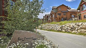 A residential area with a large rock labeled 'Bear Crossing,' a paved road, and multi-story wooden houses. - Spacious home w/ kitchen, wifi, great views, deck & convenient location (Winter Park)