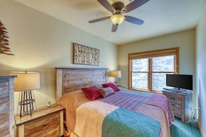 A bedroom with a bed, a ceiling fan, a window, and a TV. - Walk to the Slopes, Amazing Ski Area Views, Shared Hot Tubs Too (Keystone)