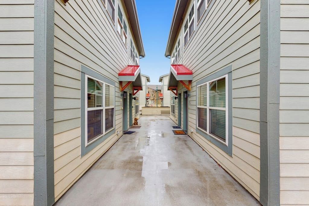 A narrow corridor between two buildings with a clear sky above.