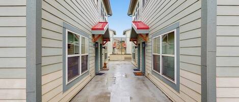 A narrow corridor between two buildings with a clear sky above.