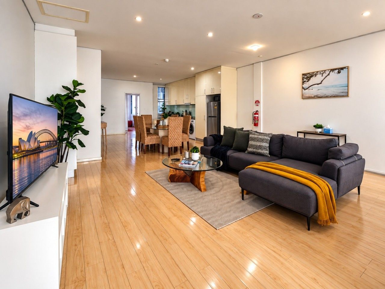 A modern living room with a sofa, coffee table, and a flat-screen TV.
