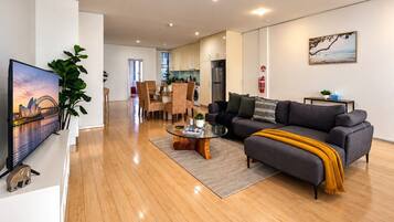 A modern living room with a sofa, coffee table, and a flat-screen TV.