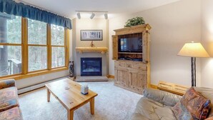 A living room with a fireplace, a television, and a sofa.