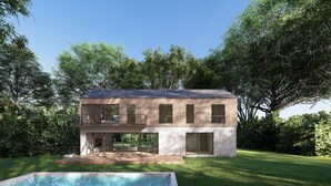 Une maison moderne à deux étages avec une piscine, entourée d’une végétation luxuriante.