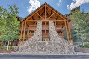 A lodge with a stone facade, wooden balconies, and a prominent entrance. - Corner condo with hot tub & private washer/dryer - steps from the slopes (Keystone)