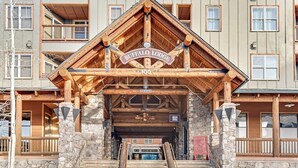 A lodge entrance with a wooden facade, stone pillars, and a sign reading 'BUFFALO LODGE.' - Spacious, resort condo w/private balcony, shared pool & hot tub. Walk to slopes (Keystone)