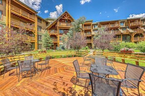 Eine mehrstöckige Lodge mit Terrassen und Sitzbereichen aus Holz.