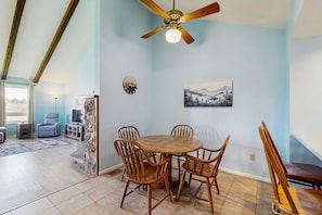 A dining area with a round wooden table and four chairs, a ceiling fan, and a painting on the wall. - Dog-friendly condo w/ covered porch & views - near golf, lakes & ski (Pagosa Springs)