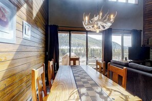 Ein Essbereich mit Holztisch, Stühlen und einer Deckenleuchte.