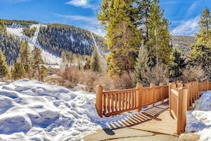 A wooden bridge over snow, surrounded by trees and a mountain. - Ski-in/ski-out home with pool, hot tub, sauna, washer/dryer, & private balcony (Keystone)