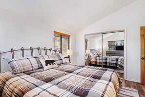 A bedroom with a bed, a mirror, and a wardrobe.