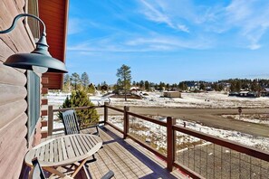 A wooden deck with a table and chairs, overlooking a snowy landscape with houses and trees. - Cozy modern cabin with private hot tub, grill, deck, balcony, & W/D (Pagosa Springs)