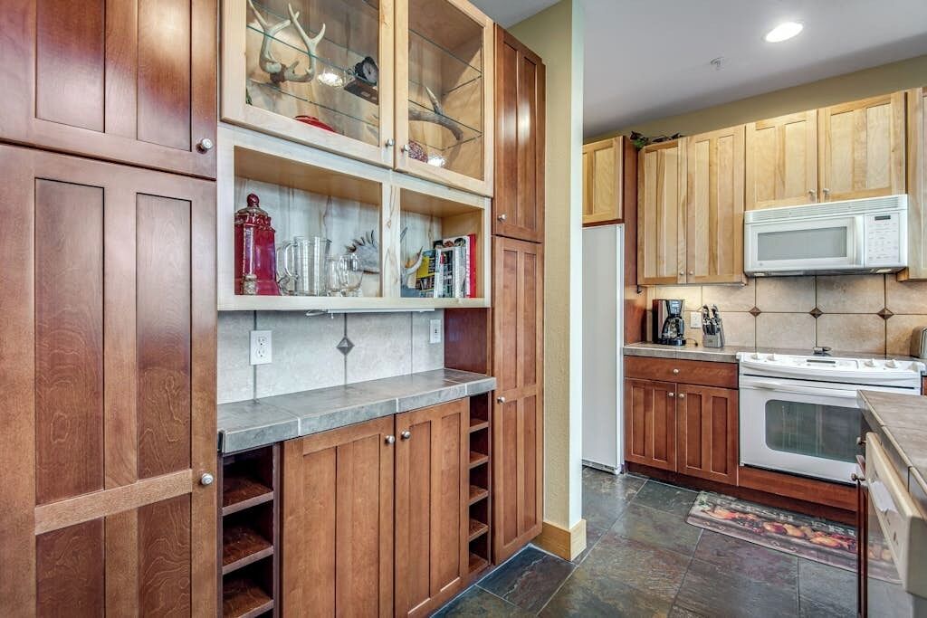 Una cocina con armarios de madera, un microondas y una estufa.