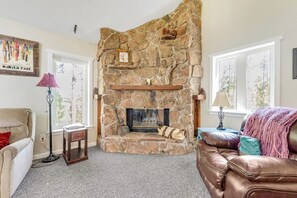 A stone fireplace with a mantel shelf, a couch, and a lamp. - Two-story dog-friendly getaway with WiFi, wood-burning fireplace, & washer/dryer (Fraser)